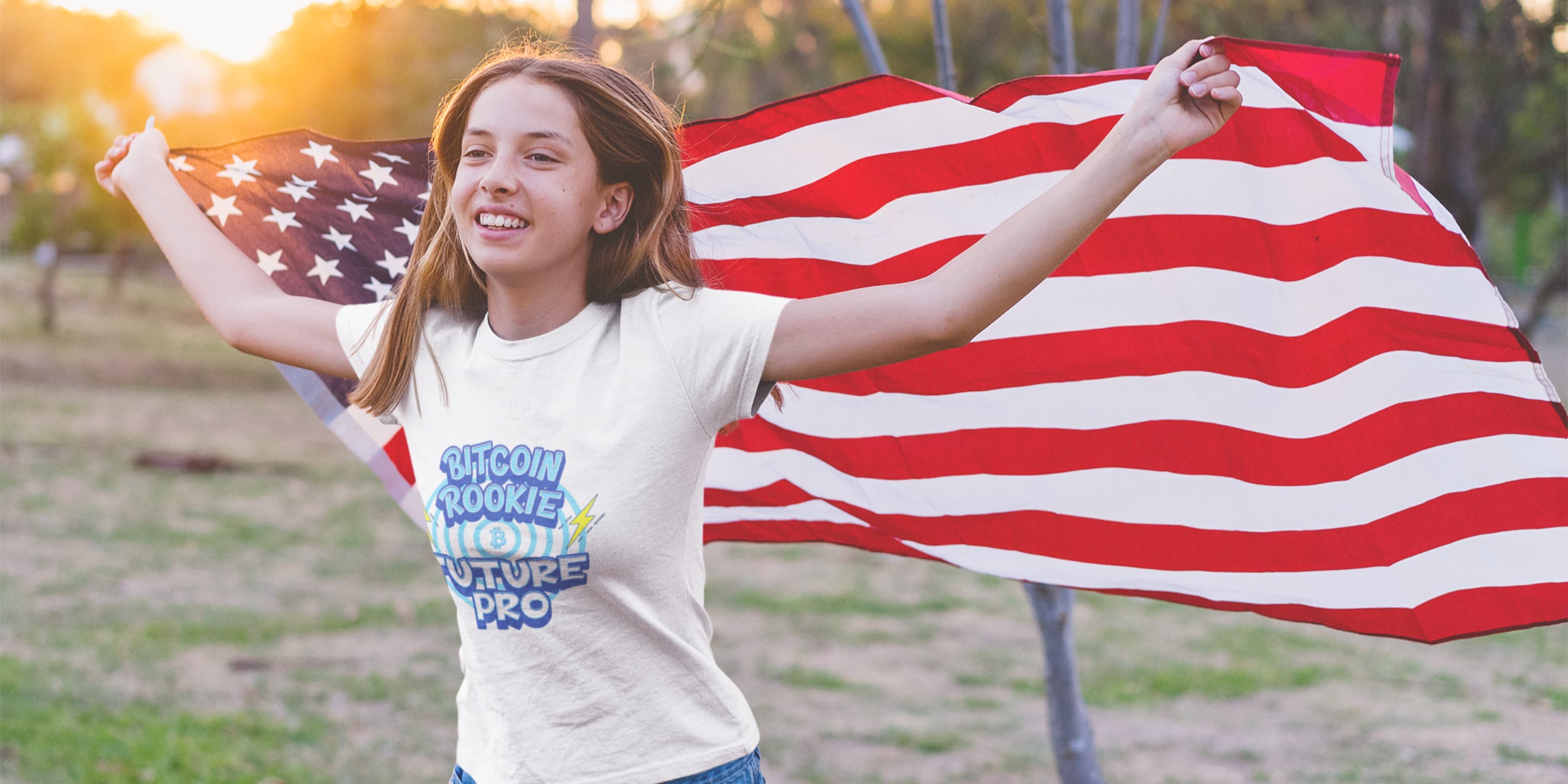 Person holding an American flag with a bitcoin white t-shirt featuring colorful text.